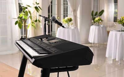 Yamaha Arranger Workstation PSR-SX720 with microphone stand at a party venue