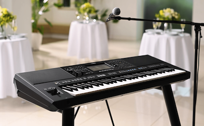 Yamaha Arranger Workstation PSR-SX920 at a party with a microphone stand.