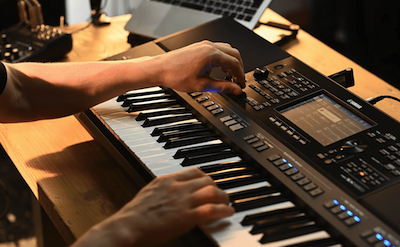 Close-up of the hand operating the Yamaha Arranger Workstation PSR-SX920.